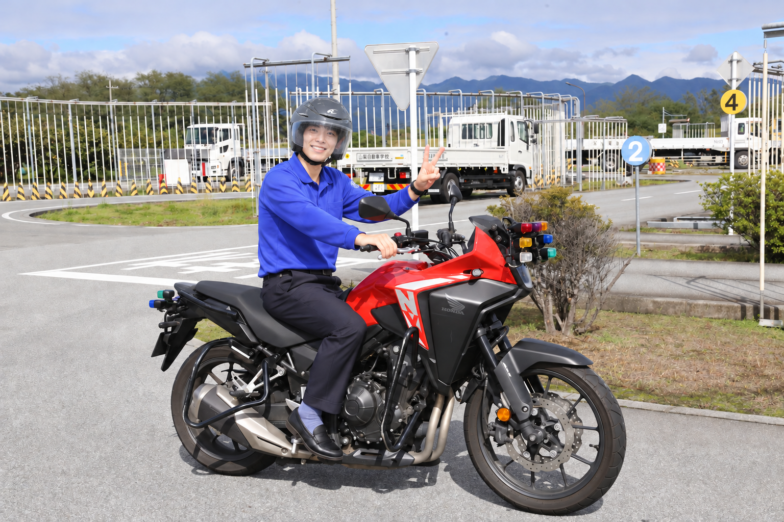 ヘルメットを着用し停車中の二輪車にまたがる指導員のイメージ